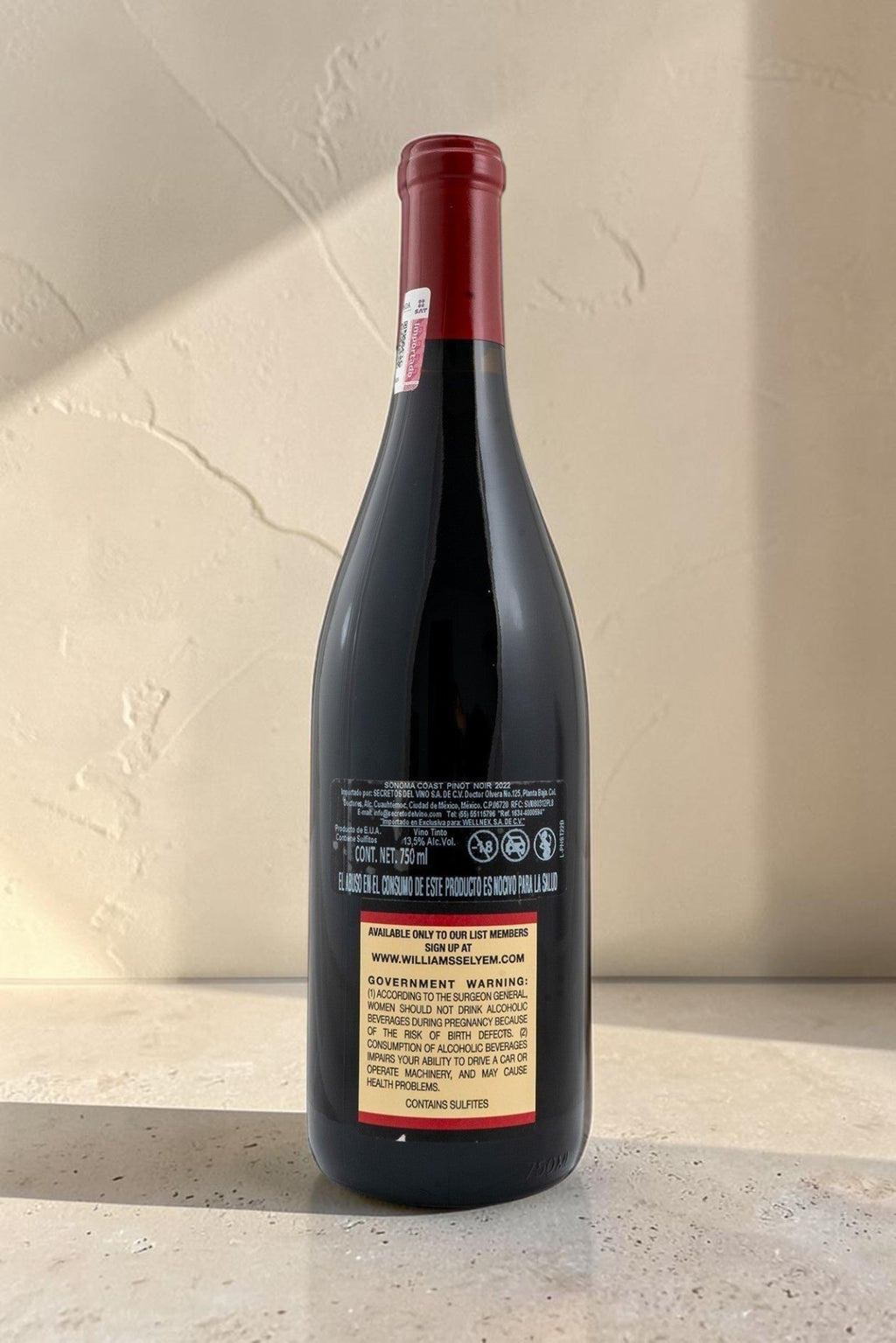 Botella de vino tinto Sonoma Coast de Wellnex con etiqueta trasera detallada y cápsula roja sobre fondo neutro.