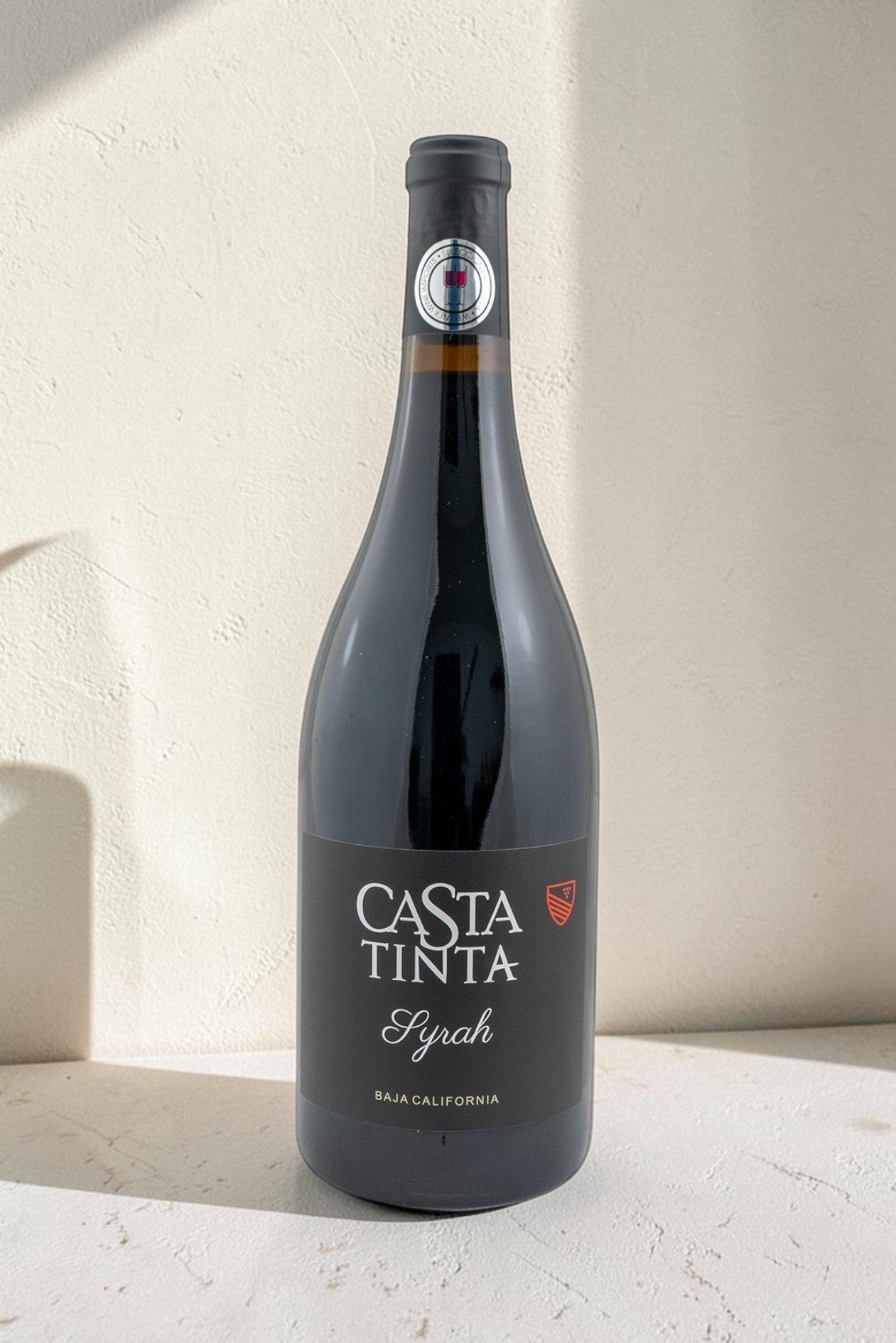 Botella de vino tinto Syrah Casta Tinta de Wellnex con etiqueta negra elegante sobre fondo neutro