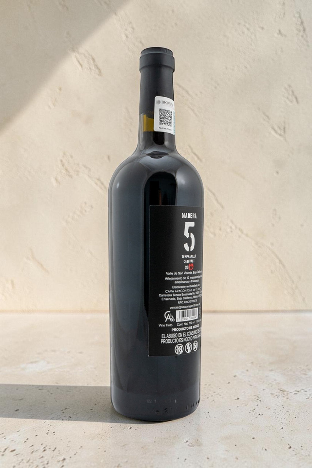 Botella de vino tinto Wellnex Madera 5 Tempranillo Cabernet con etiqueta informativa sobre fondo neutro