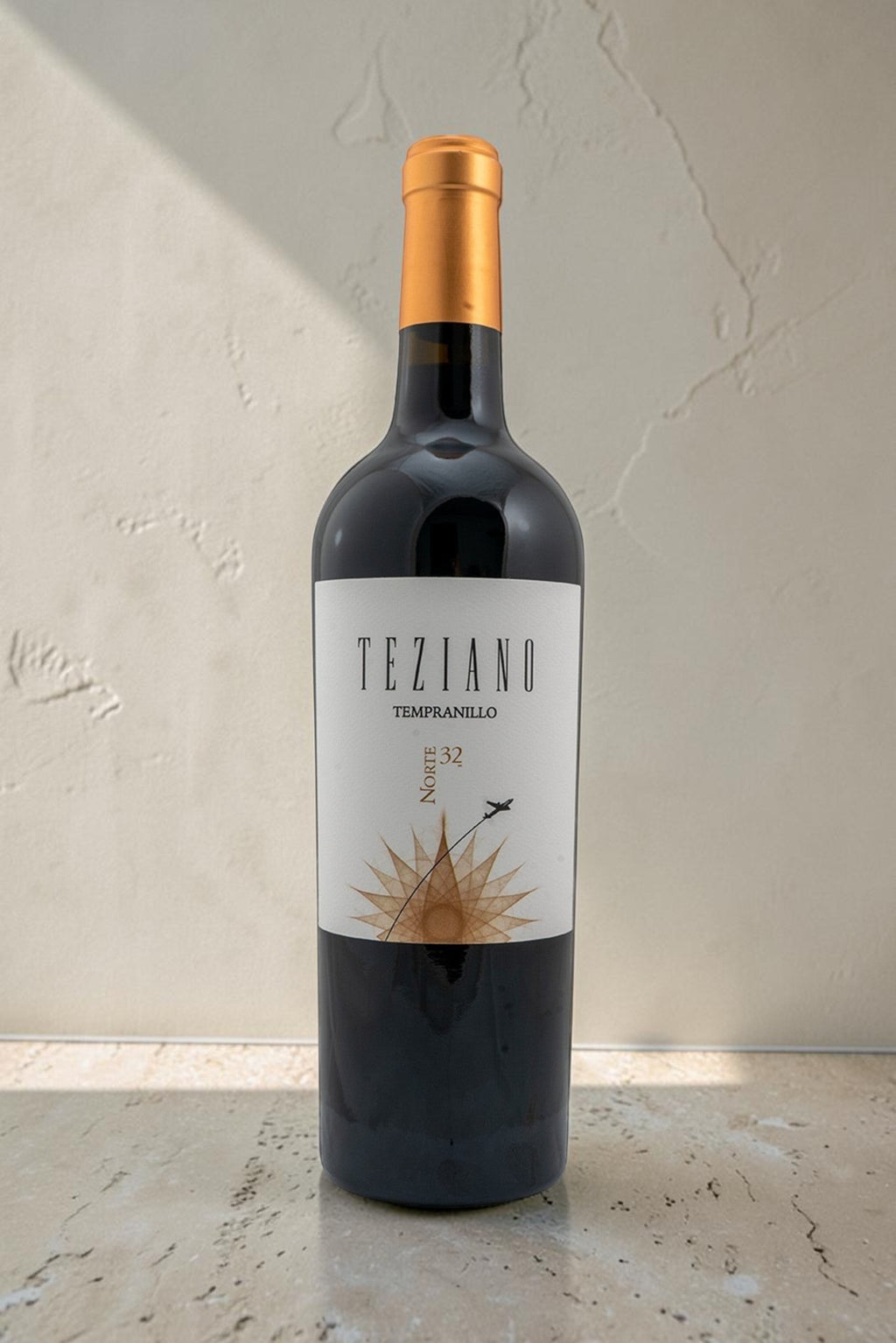 Botella de vino tinto Teziano Tempranillo de Wellnex con etiqueta elegante y tapón dorado sobre fondo neutro