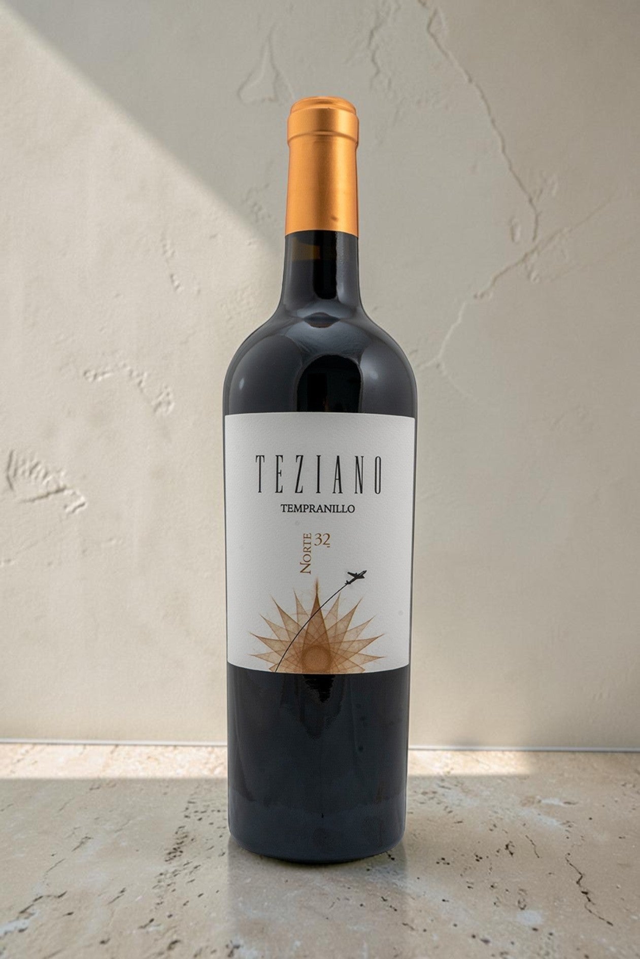 Botella de vino tinto Teziano Tempranillo de Wellnex con etiqueta elegante y tapón dorado sobre fondo neutro