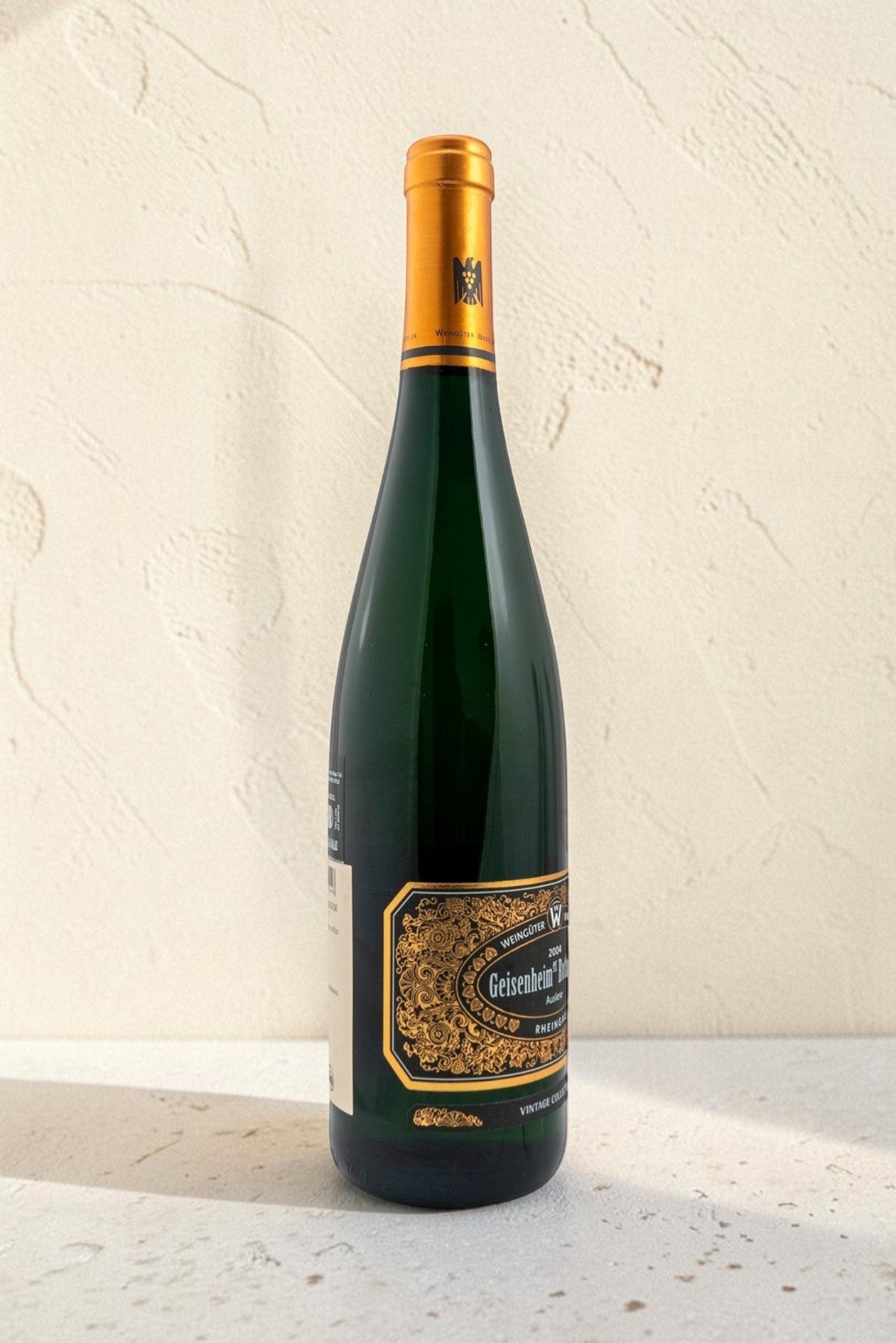 Botella de vino blanco Wellnex Weingut Wegeler Geisenheim Rothenberg Riesling Auslese con etiqueta dorada y elegante